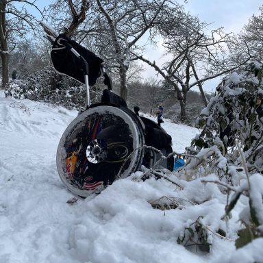 Ein Rollstuhl auf einem verschneiten Weg.